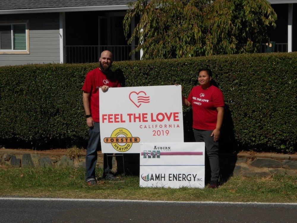 Vanessa and Joe in front of the Feel the Love sign